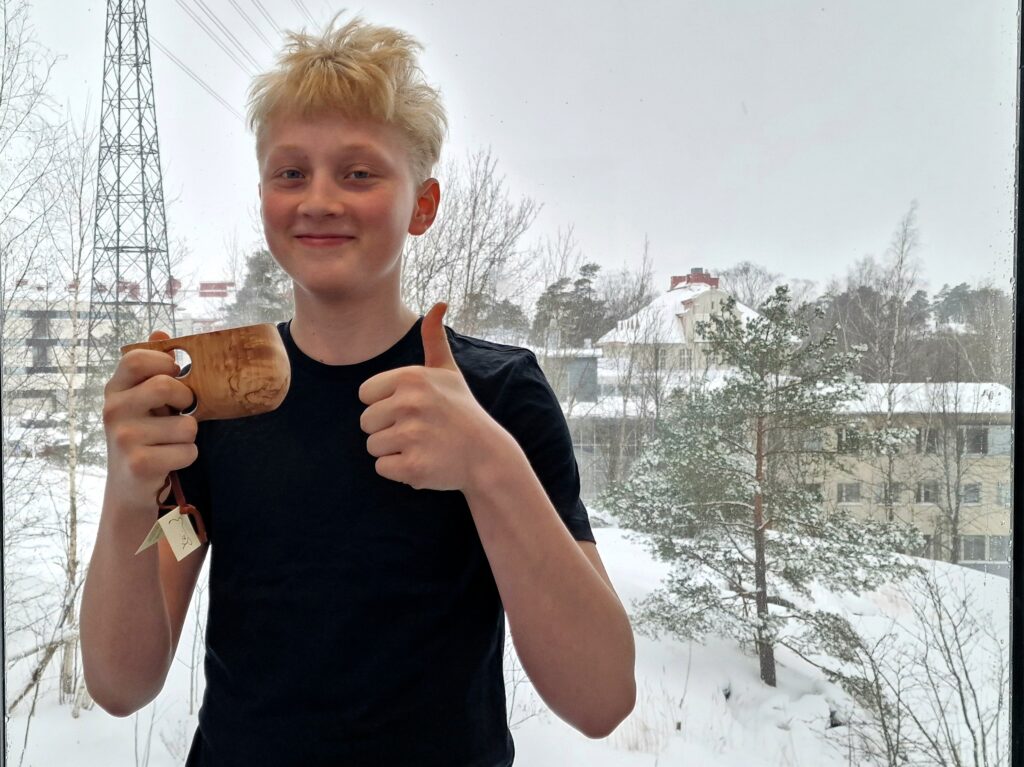 Metsävisan voittaja Elian pitää kädessään palkintoaan, kuksaa.