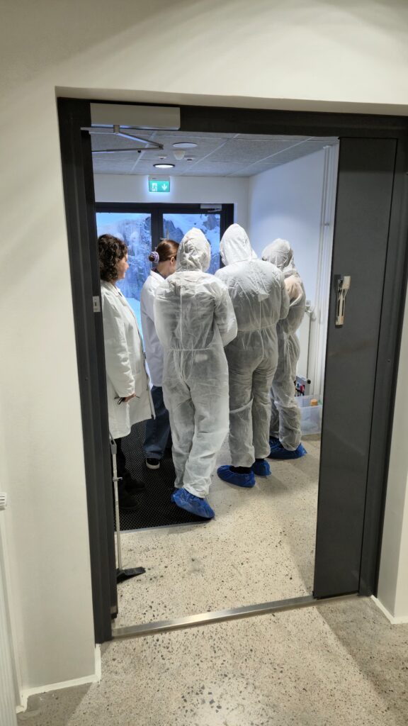 Rikostekninen tutkimus:
Opiskelijat valmistautumassa  tutkimaan rikospaikkaa valkoiset suojapuvut yllään.  
