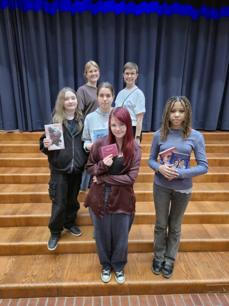 Joukko lukemisesta innostuneita nuoria osallistui lukuhaasteeseen, jossa luettujen kirjojen määrää vasten sai erilaisia palkintoja. Kuvassa (vas.) lukuhaasteen järjestäjät Saara ja Meri sekä kirjapalkinnon voittaneita oppilaita.